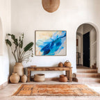 Foyer with a wooden console table, original abstract painting, and decorative vases.