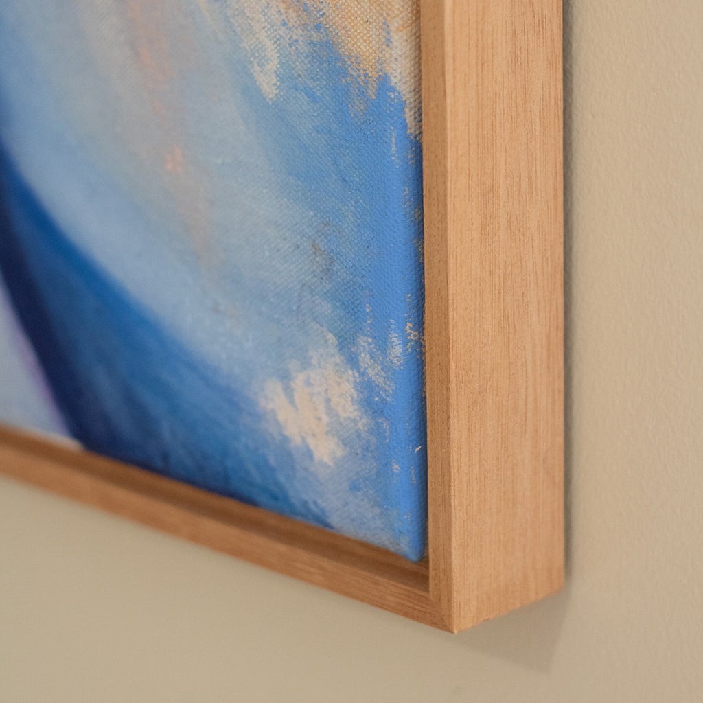 Close-up of a painting with a wooden frame on a beige wall